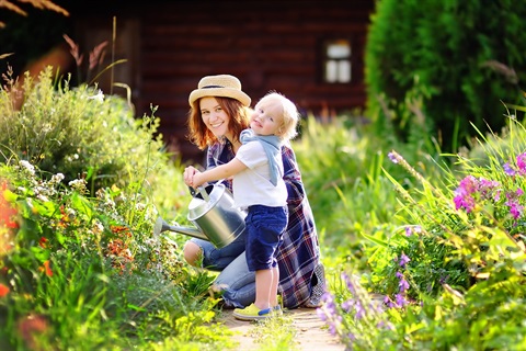 Photo of woman and child watering in the garden 
